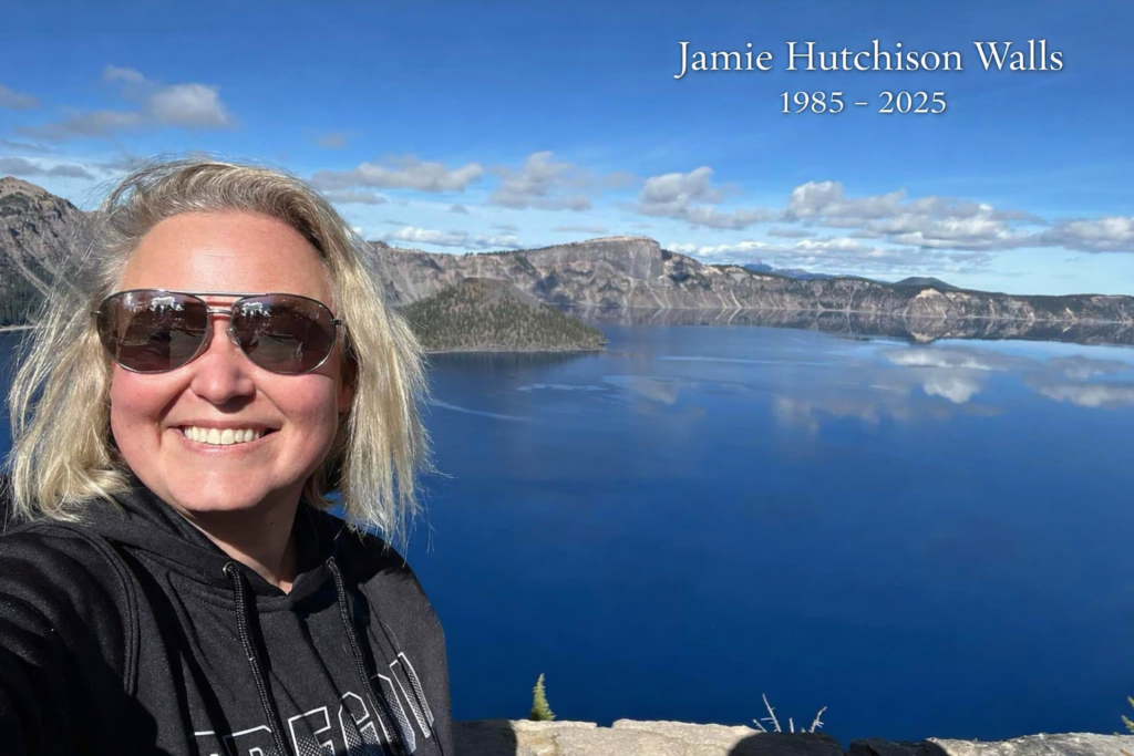 Jamie Hutchison Walls smiling at Crater Lake with blue sky and lake in the background
